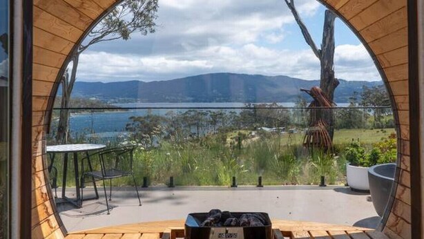 A wooden deck with a bench and a table, overlooking a lake and mountains. - Mabels Lookout - Sauna| Bath| Sunsets| Views| Fire (North Bruny)