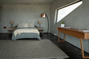 A modern bedroom with a bed, bedside tables, a desk, and a large window. - Mabels Lookout - Sauna| Bath| Sunsets| Views| Fire (North Bruny)