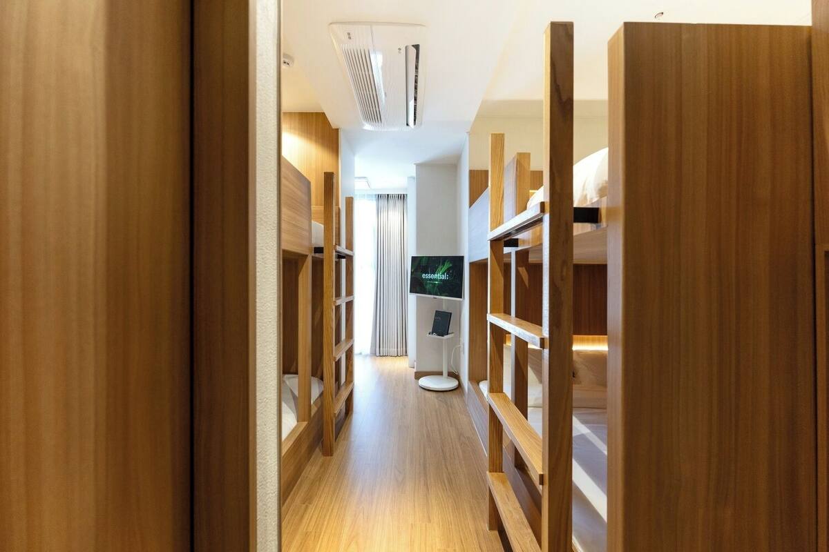 Ein moderner Hotelkorridor mit Holzbögen und einem flachbildfernseher an der Wand.