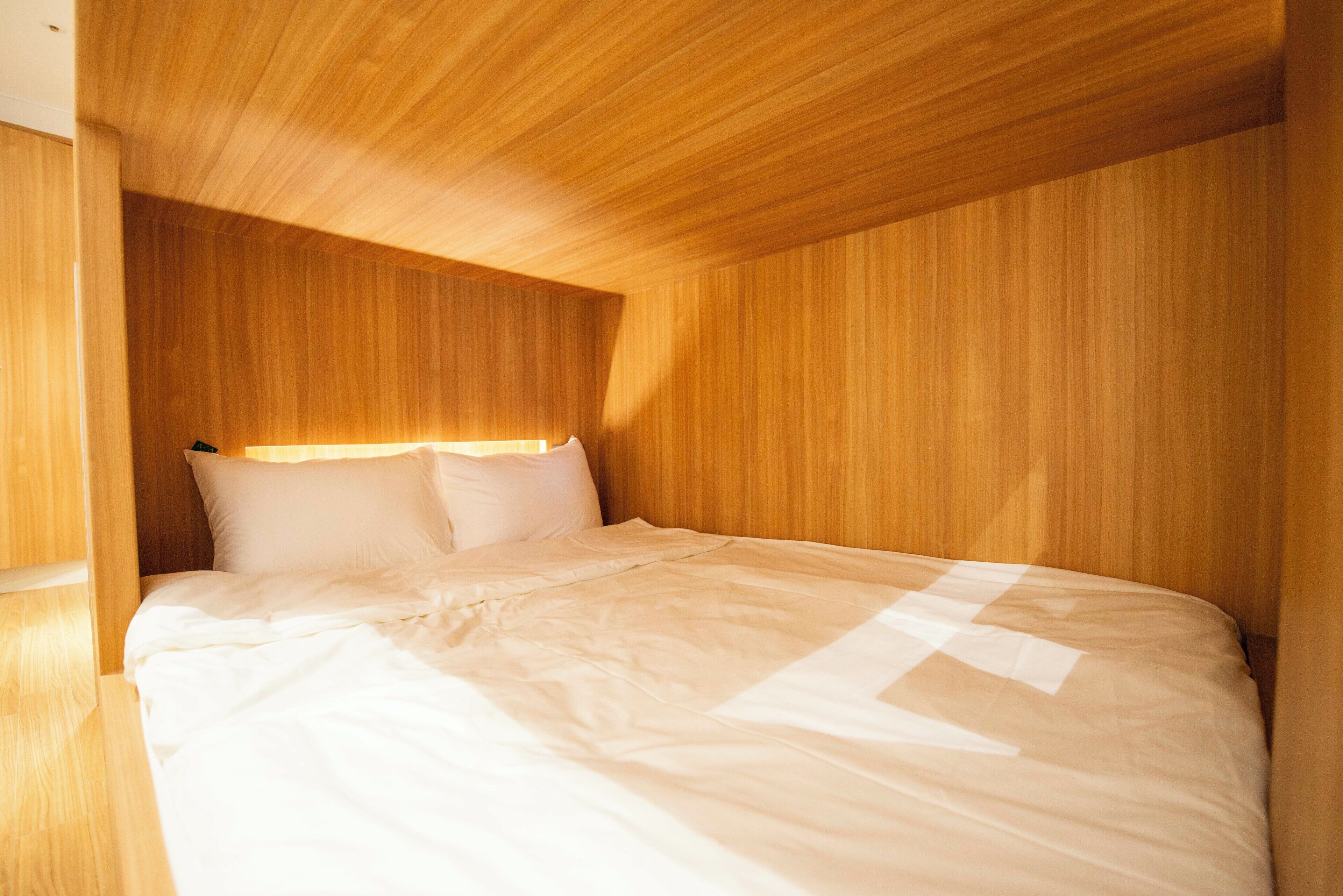 A single bed in a room with wooden paneling on the walls and ceiling.
