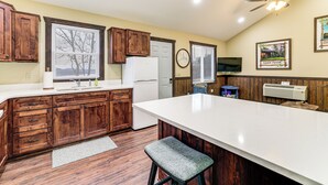 A kitchen with wooden cabinets, a white countertop, a built-in stove, and a ceiling fan. - Stunning Views! Table Rock Lake Cabin Near Marina (Shell Knob)