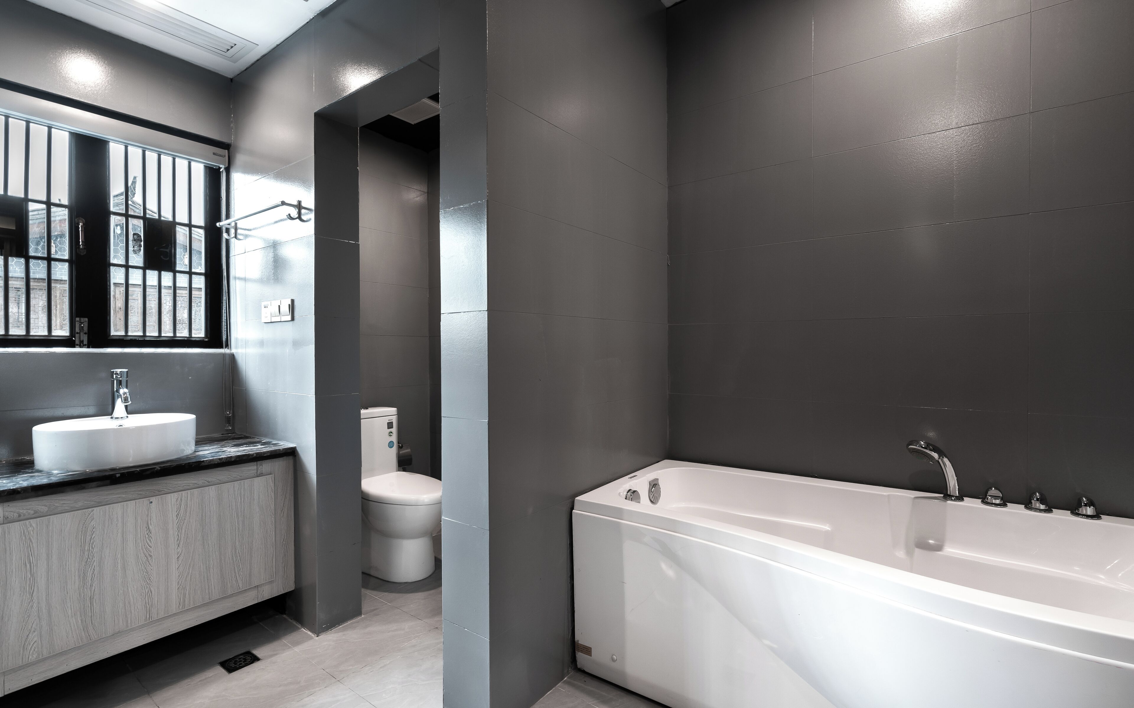 Ein modernes Badezimmer mit einer großen Badewanne, einem Waschbecken und einer Toilette.