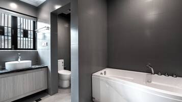 Ein modernes Badezimmer mit einer großen Badewanne, einem Waschbecken und einer Toilette.