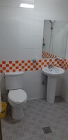Un baño con inodoro, lavamanos y ducha.