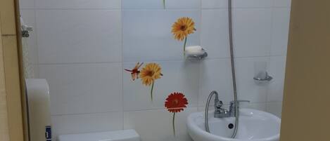 A bathroom with a toilet, sink, and shower.