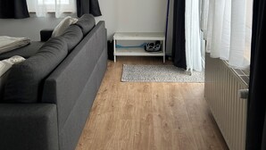 A modern room with a sofa, a coat rack, a small table, and a radiator. - Beautiful vacation apartment in the Altmark (Goldbeck)