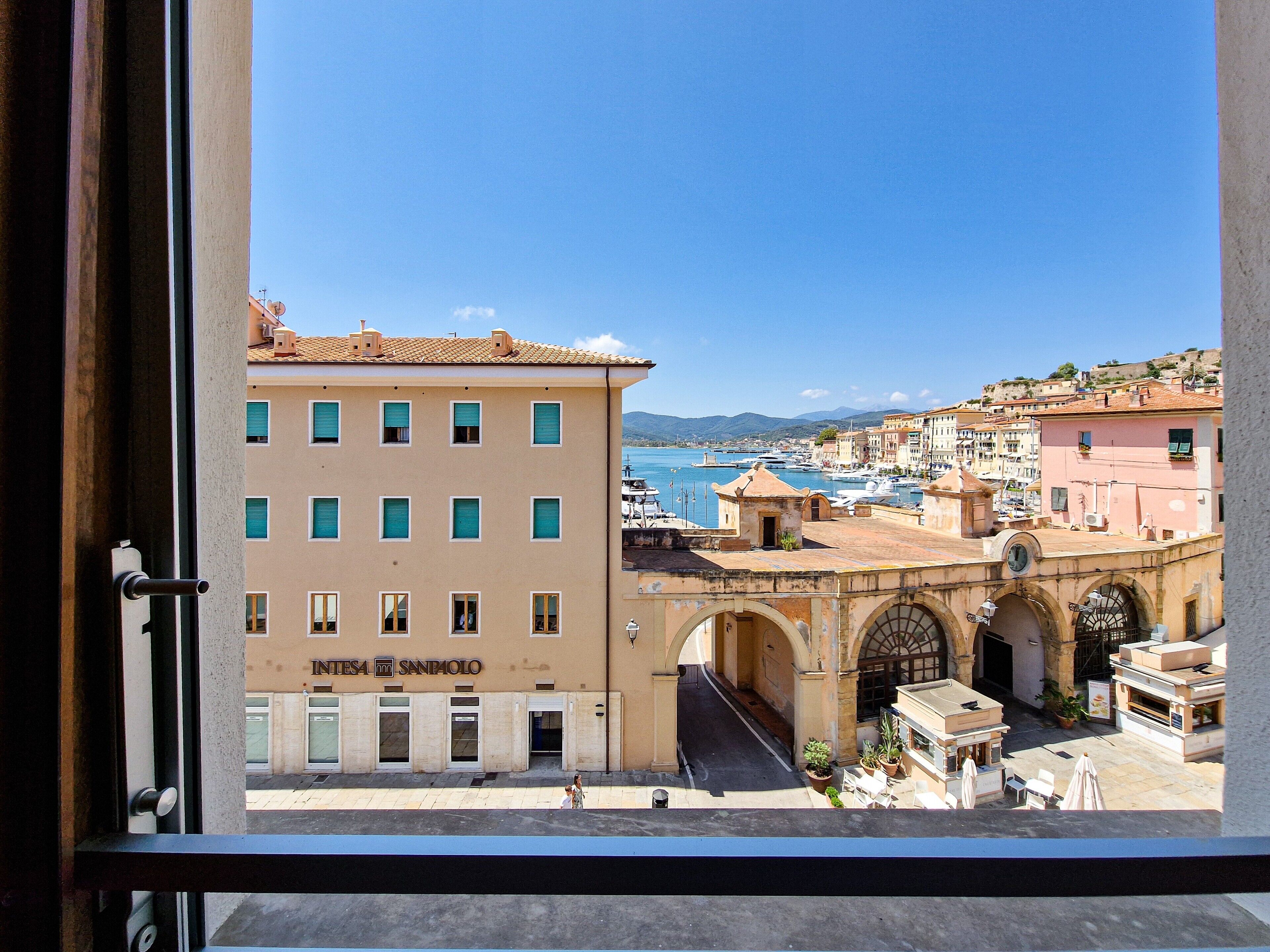 Une vue d’une ville côtière, avec ses bâtiments, un ciel dégagé et une étendue d’eau.