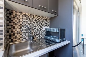 Apartamento, vista para a cidade | Cozinha privada | Geladeira grande, micro-ondas, fogão, cooktop
