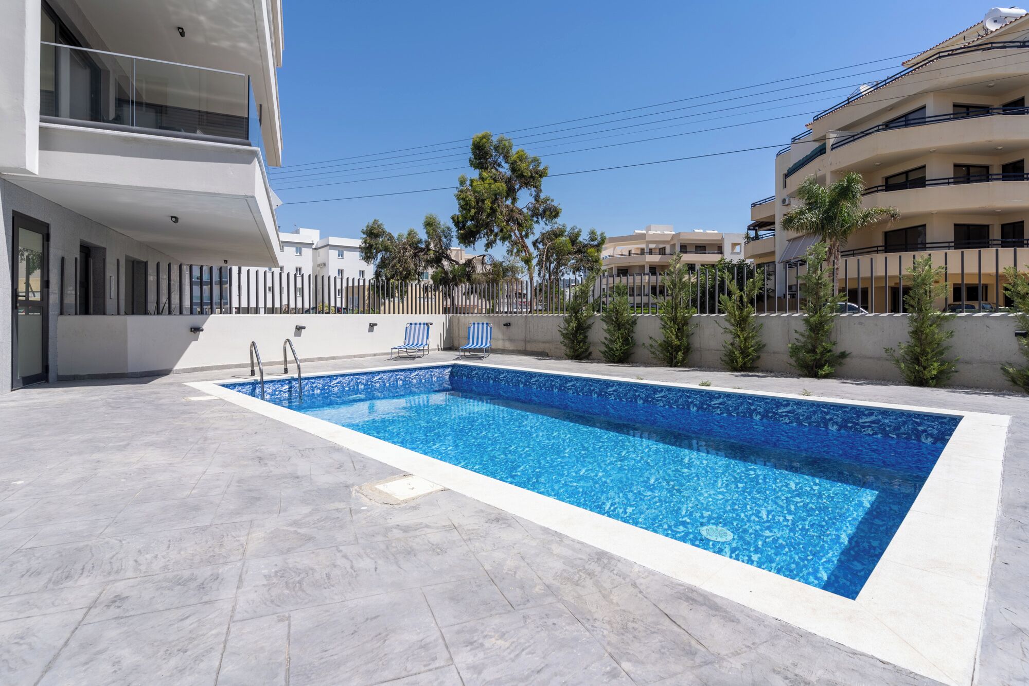A rectangular swimming pool with a clear blue water surface, surrounded by a tiled deck.