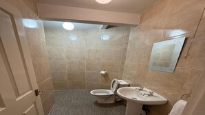Ein kleines Badezimmer mit Toilette, Waschbecken und Spiegel.