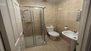 Ein Badezimmer mit Duschkabine, Toilette und Waschbecken.