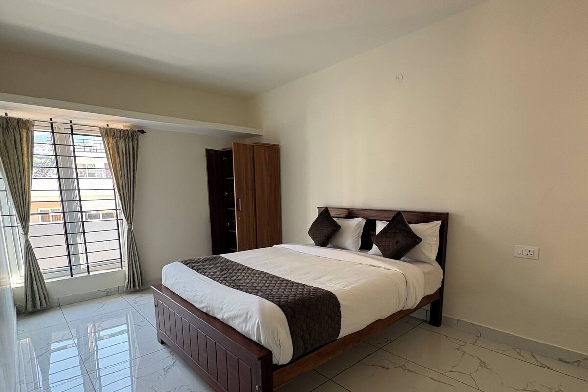 Une chambre à coucher avec un lit, une armoire et une fenêtre avec des rideaux.
