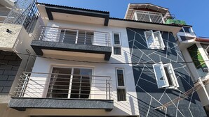 A multi-story residential building with balconies, a gated entrance, and a geometric facade design. - BBR Holiday Home (Ooty)