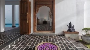 A hallway with a tiled floor, a wooden door, and a mirror reflecting a room. - TAAVETTI (Galle)