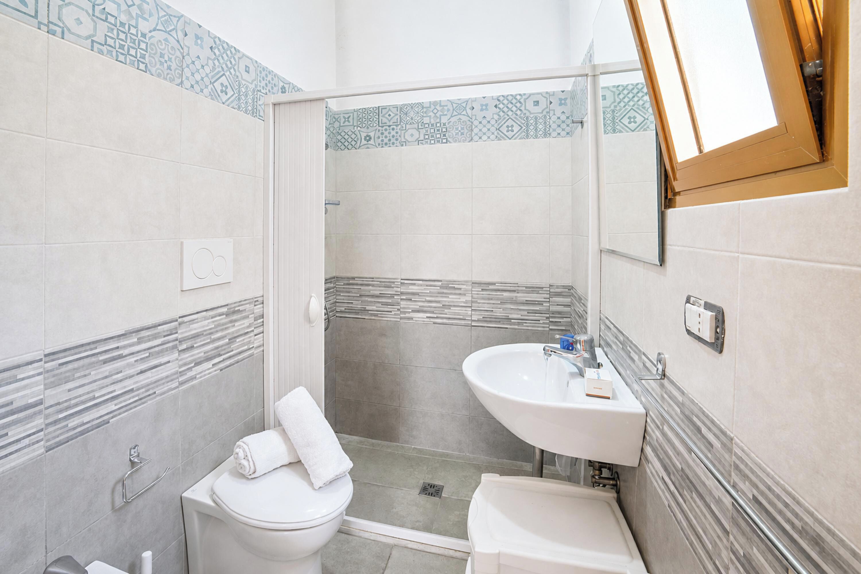 A bathroom with a toilet, sink, and shower.