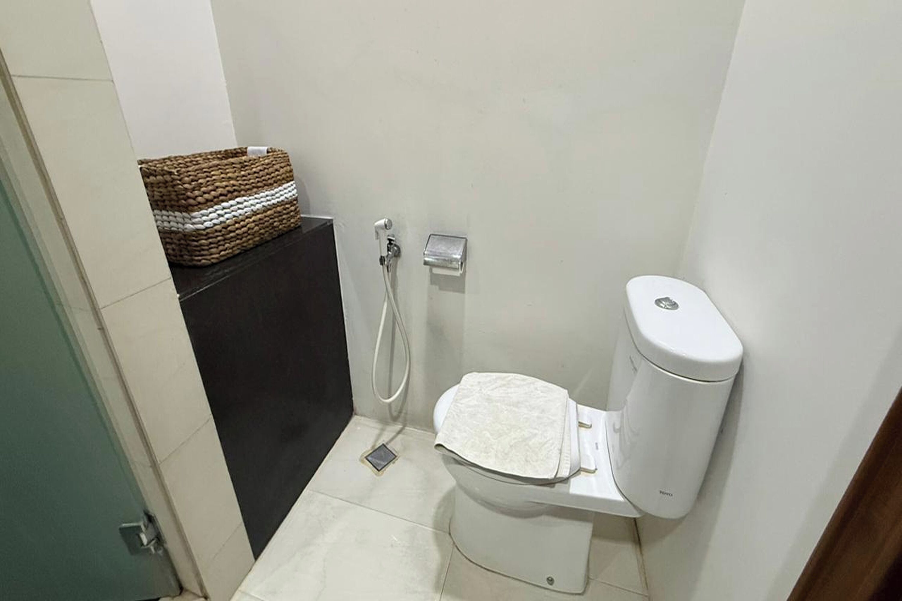 A small, compact bathroom with a toilet, a bidet, and a shower.