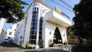 A white building with a large arched entrance and a sign above it. - Madina inn Hotel & Hostel Yogyakarta (Yogyakarta)