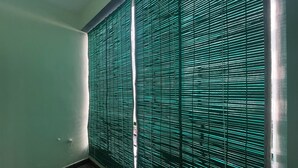 Una habitación con un ventanal grande cubierto por persianas horizontales.