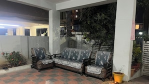 Un espacio al aire libre cubierto con cojines estampados y piso de baldosas.