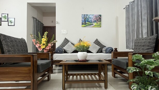 Una sala de estar con un conjunto de sofá, una mesita de centro y una planta en maceta.