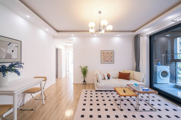 Un salon moderne avec un canapé, une table basse et un coin repas.