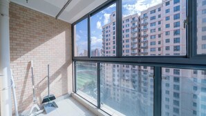 A room with a large window, a brick wall, and a floor with cleaning equipment. - Tyms Tianshan 2BR near Riverside Park (Shanghai)