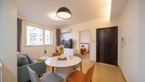 A modern living room with a dining area, a TV, and a view of the city. - Tyms Tianshan 2BR near Riverside Park (Shanghai)
