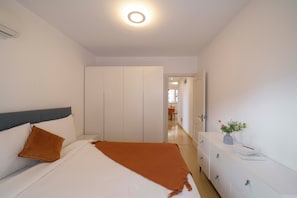 A bedroom with a bed, a wardrobe, a dresser, and a door leading to another room. - Tyms Tianshan 2BR near Riverside Park (Shanghai)