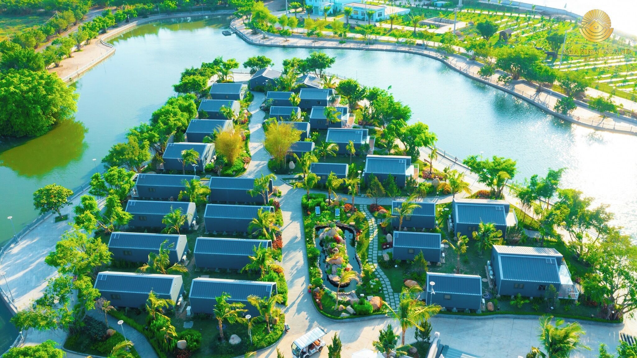 An aerial view of a resort with multiple buildings arranged around a central water feature, connected by pathways.