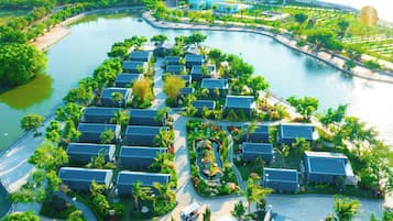 An aerial view of a resort with multiple buildings arranged around a central water feature, connected by pathways.