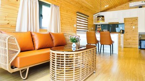 A wooden interior with a sofa, wicker coffee table, and chairs. - Amazing Island Resort (Long Hung)