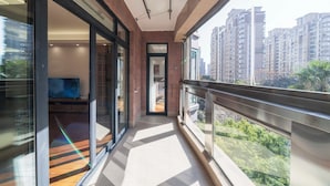 A balcony with a view of high-rise buildings and greenery. - Tyms Gubei Apt 2BR Residence near Gubei (Shanghai)