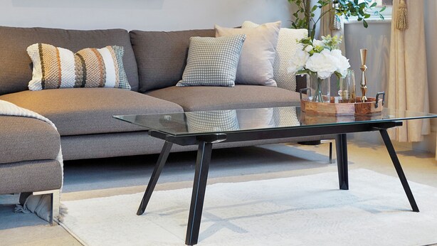 A modern living room with a sectional sofa, a glass coffee table, and a large abstract painting. - Central Mayfair Luxury Apartments (London)