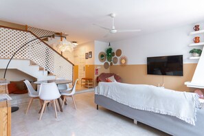 A modern living space with a staircase, a dining area, a bed, and a TV. - Summer Azul 3 Casa Lena by Casasol (Nerja)