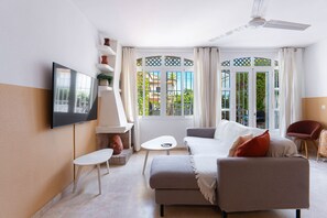 A modern living room with a flat-screen TV, a sofa, a coffee table, and a chair. - Summer Azul 3 Casa Lena by Casasol (Nerja)
