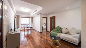 A modern living room with a sofa, a coffee table, and a dining area with a table and chairs. - Tyms Gubei Apt 2BR near Metro Plaza (Shanghai)