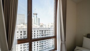 A hotel room with a large window, curtains, and a bed. - Tyms Gubei Apt 2BR near Metro Plaza (Shanghai)