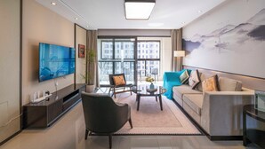 Una sala de estar moderna con una televisión de pantalla plana, un sofá, una silla y una mesa de centro.