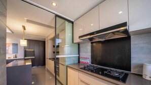 Una cocina moderna con separador de vidrio, electrodomésticos de acero inoxidable y diseño minimalista.
