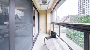 A modern hotel room with a large window, a marble table, and a black chair. - Tyms Gubei Apt 2BR Apt Near Takashimaya (Shanghai)
