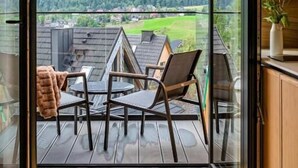 Ein Balkon mit Blick auf Berge und einer Holzterrasse.