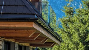 Ein modernes Gebäude mit Holzfassade und einem Balkon mit Blick auf einen Berg.