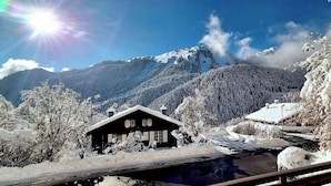Een besneeuwd berglandschap met een blokhut en een klein gebouw.
