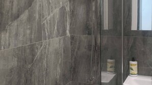 A modern bathroom with a glass-enclosed shower, a white bathtub, and a vanity with a mirror. - Modern & Stylish Retreat  15 Mins to Central London (Barking)