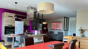 Eine moderne Küche mit Essbereich, einem roten Tisch und einer violetten Wand.