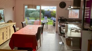 Eine moderne Küche mit Essbereich, einem großen Fenster und Blick auf den Garten.