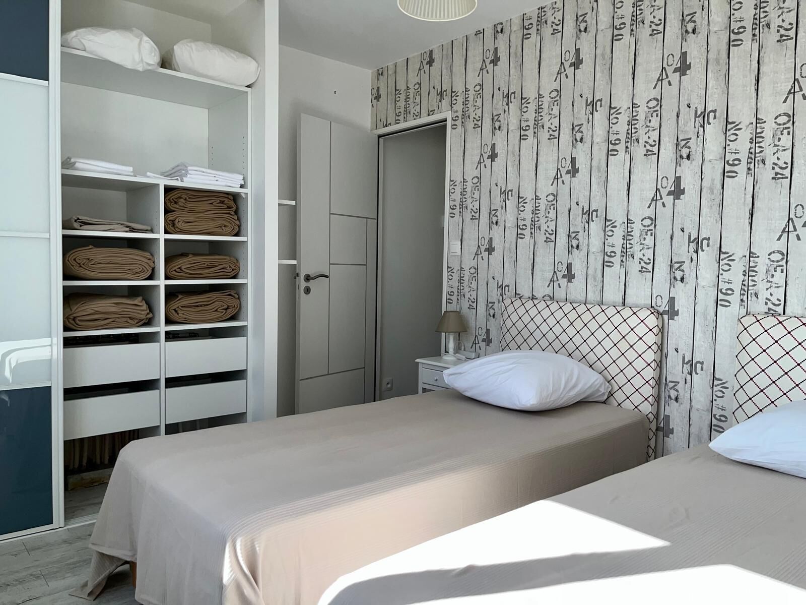 A bedroom with a bed, a wardrobe, and a nightstand.