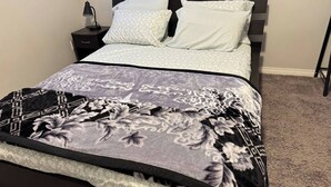 Una cama con un edredón estampado con motivos florales y dos almohadas.