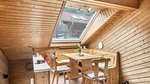 A wooden interior with a sloped ceiling and a skylight.