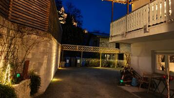 Ein Innenhof mit überdachter Sitzgelegenheit, einem Holzzaun und einem Gebäude mit Balkon.